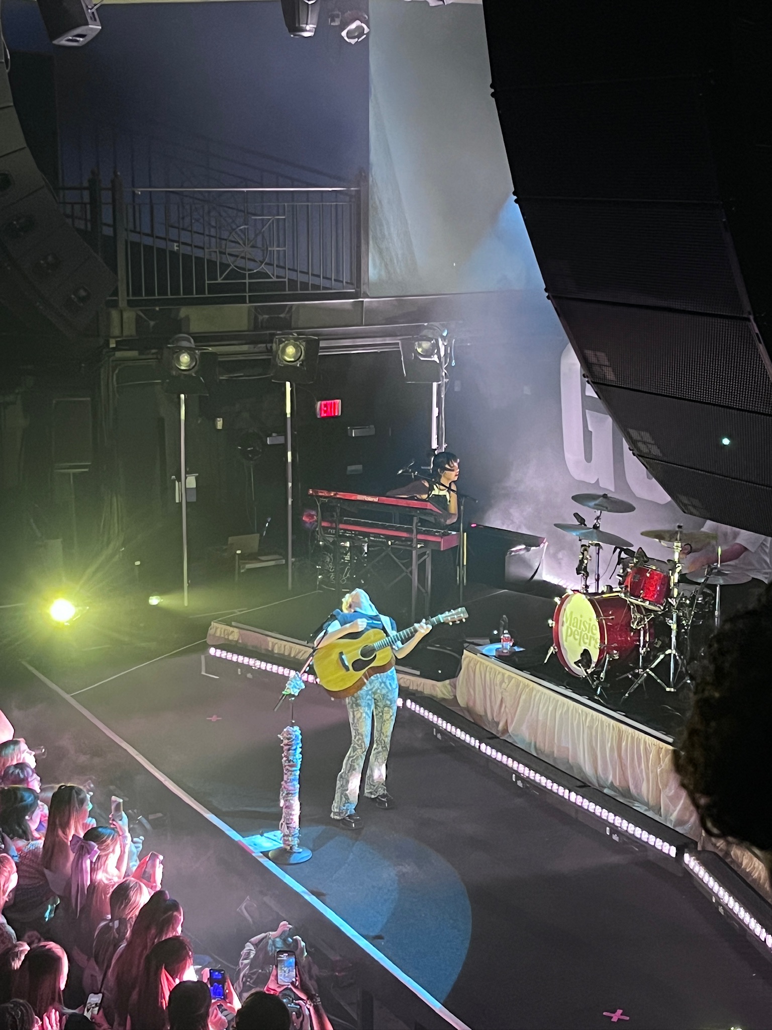 Maisie Peters playing guitar at her concert