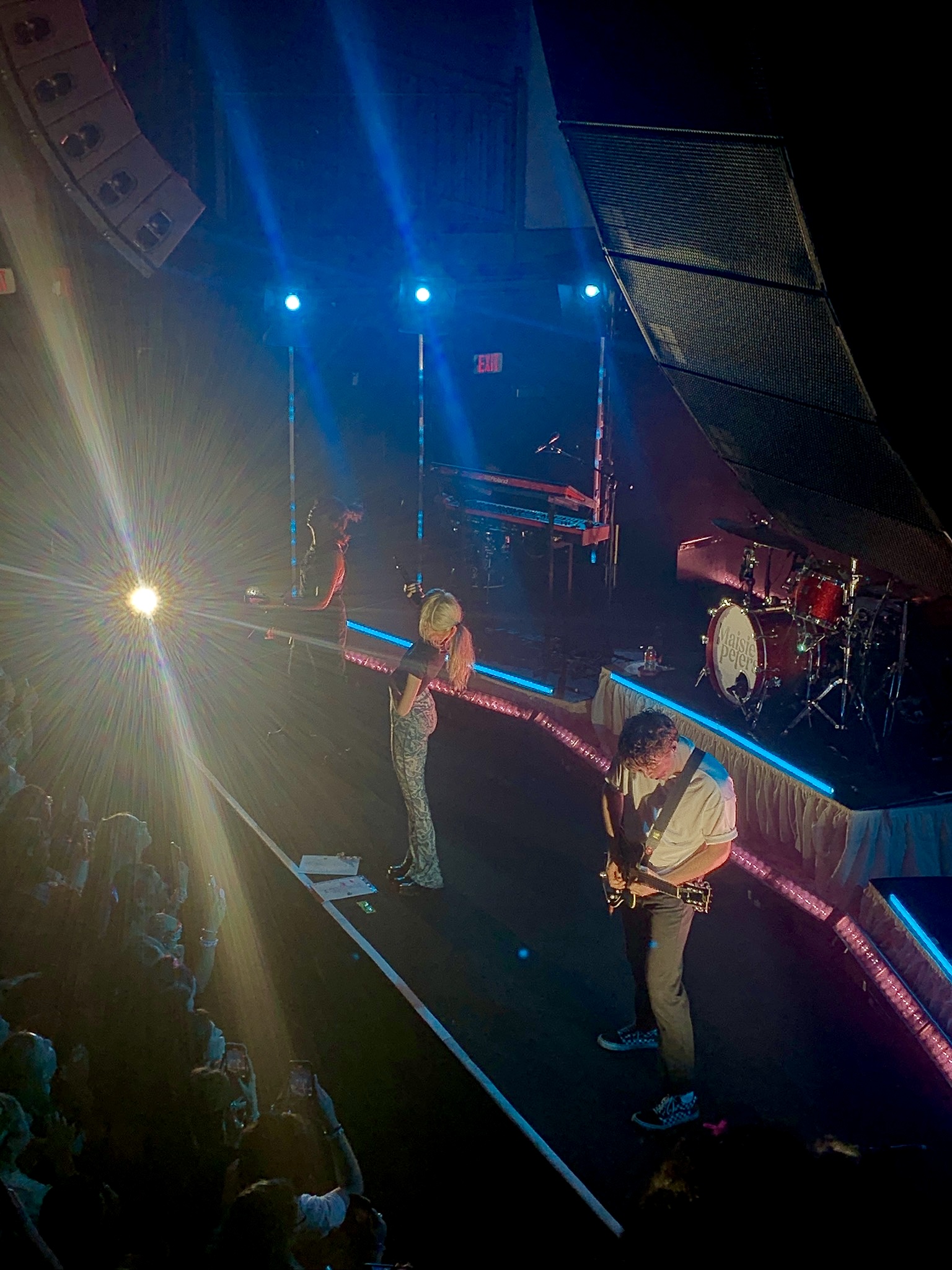 Maisie  Peters singing on stage with her band