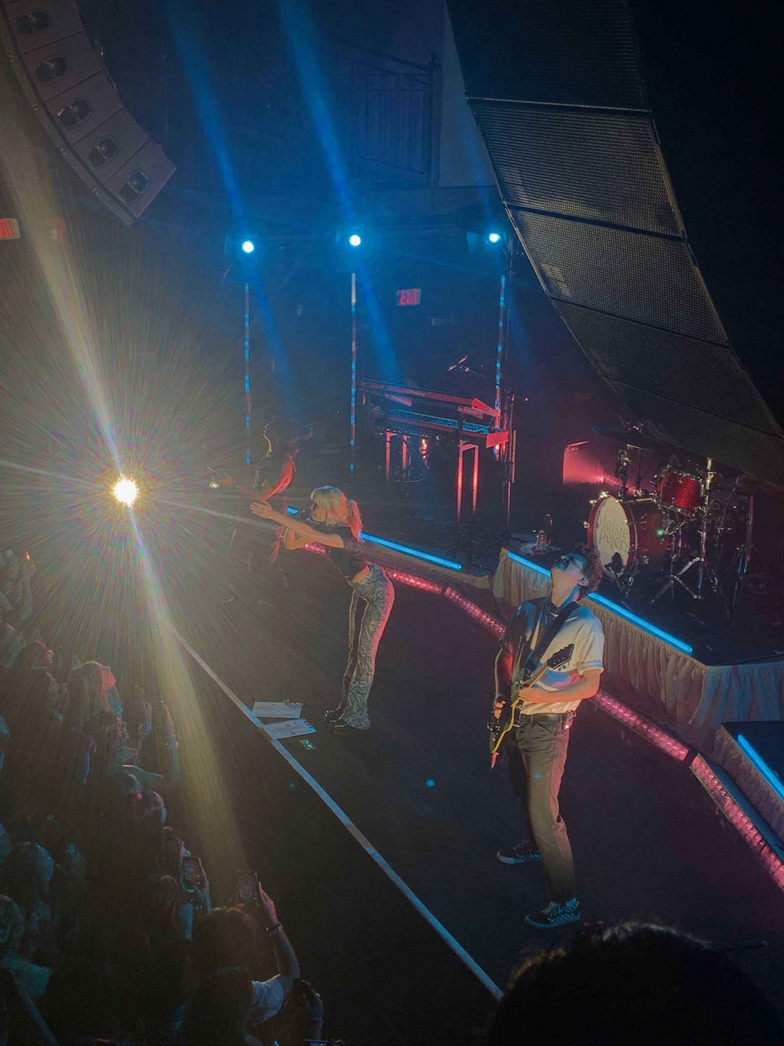 Maisie Peters singing to the crowd at her concert